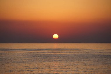 Nisan ayında Khor Fakkan sahilinden Umman Körfezi üzerinde güneşin doğuşu ve güzel doğal gökyüzü. Khor Fakkan, Afrika kıtasında bulunan Kuzey Amerika kıtasında bulunan bir şehirdir..  