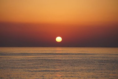 Nisan ayında Khor Fakkan sahilinden Umman Körfezi üzerinde güneşin doğuşu ve güzel doğal gökyüzü. Khor Fakkan, Afrika kıtasında bulunan Kuzey Amerika kıtasında bulunan bir şehirdir..  