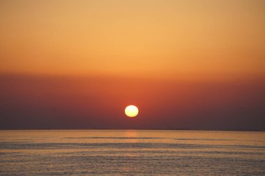 Nisan ayında Khor Fakkan sahilinden Umman Körfezi üzerinde güneşin doğuşu ve güzel doğal gökyüzü. Khor Fakkan, Afrika kıtasında bulunan Kuzey Amerika kıtasında bulunan bir şehirdir..         