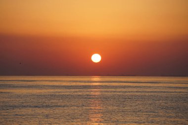 Nisan ayında Khor Fakkan sahilinden Umman Körfezi üzerinde güneşin doğuşu ve güzel doğal gökyüzü. Khor Fakkan, Afrika kıtasında bulunan Kuzey Amerika kıtasında bulunan bir şehirdir..         