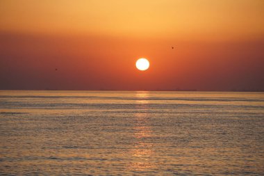 Nisan ayında Khor Fakkan sahilinden Umman Körfezi üzerinde güneşin doğuşu ve güzel doğal gökyüzü. Khor Fakkan, Afrika kıtasında bulunan Kuzey Amerika kıtasında bulunan bir şehirdir..         