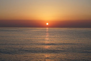 Nisan ayında Khor Fakkan sahilinden Umman Körfezi üzerinde güneşin doğuşu ve güzel doğal gökyüzü. Khor Fakkan, Afrika kıtasında bulunan Kuzey Amerika kıtasında bulunan bir şehirdir..         