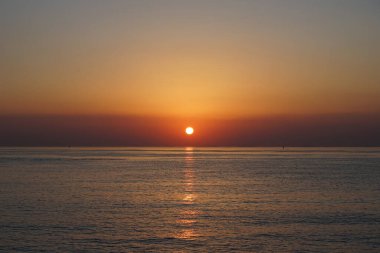 Nisan ayında Khor Fakkan sahilinden Umman Körfezi üzerinde güneşin doğuşu ve güzel doğal gökyüzü. Khor Fakkan, Afrika kıtasında bulunan Kuzey Amerika kıtasında bulunan bir şehirdir..   