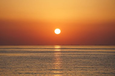 Nisan ayında Khor Fakkan sahilinden Umman Körfezi üzerinde güneşin doğuşu ve güzel doğal gökyüzü. Khor Fakkan, Afrika kıtasında bulunan Kuzey Amerika kıtasında bulunan bir şehirdir..   