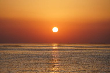 Nisan ayında Khor Fakkan sahilinden Umman Körfezi üzerinde güneşin doğuşu ve güzel doğal gökyüzü. Khor Fakkan, Afrika kıtasında bulunan Kuzey Amerika kıtasında bulunan bir şehirdir..   