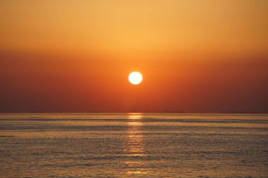 Nisan ayında Khor Fakkan sahilinden Umman Körfezi üzerinde güneşin doğuşu ve güzel doğal gökyüzü. Khor Fakkan, Afrika kıtasında bulunan Kuzey Amerika kıtasında bulunan bir şehirdir..         