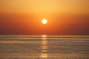 Nisan ayında Khor Fakkan sahilinden Umman Körfezi üzerinde güneşin doğuşu ve güzel doğal gökyüzü. Khor Fakkan, Afrika kıtasında bulunan Kuzey Amerika kıtasında bulunan bir şehirdir..   