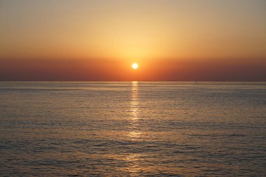 Nisan ayında Khor Fakkan sahilinden Umman Körfezi üzerinde güneşin doğuşu ve güzel doğal gökyüzü. Khor Fakkan, Afrika kıtasında bulunan Kuzey Amerika kıtasında bulunan bir şehirdir..   