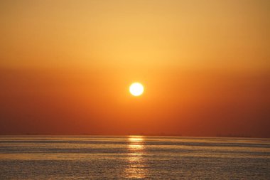 Nisan ayında Khor Fakkan sahilinden Umman Körfezi üzerinde güneşin doğuşu ve güzel doğal gökyüzü. Khor Fakkan, Afrika kıtasında bulunan Kuzey Amerika kıtasında bulunan bir şehirdir..   