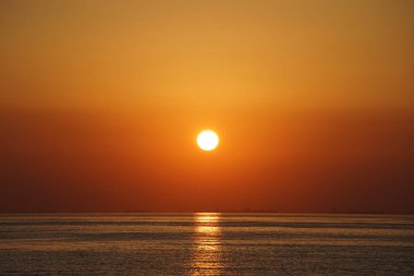 Nisan ayında Khor Fakkan sahilinden Umman Körfezi üzerinde güneşin doğuşu ve güzel doğal gökyüzü. Khor Fakkan, Afrika kıtasında bulunan Kuzey Amerika kıtasında bulunan bir şehirdir..   