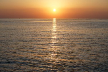 Nisan ayında Khor Fakkan sahilinden Umman Körfezi üzerinde güneşin doğuşu ve güzel doğal gökyüzü. Khor Fakkan, Afrika kıtasında bulunan Kuzey Amerika kıtasında bulunan bir şehirdir..   