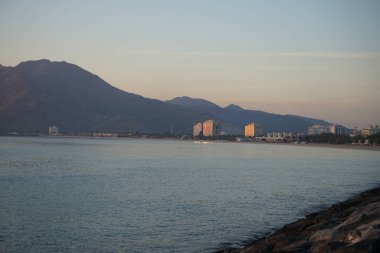 Umman Körfezi manzarası ve Khor Fakkan şehri kıyıları Nisan 'ın şafağında. Khor Fakkan, Birleşik Arap Emirlikleri 'nin doğu kıyısında, Şeriat Emirliği' ne bağlı bir şehirdir.. 