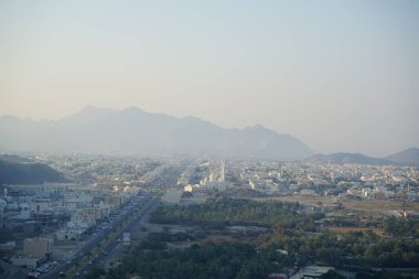 Al Suwaifa Yürüyüş Yolu 'ndaki dağdan Khor Fakkan şehri ve beyaz Al-Lo' alo 'aeyyah Camii manzarası. Khor Fakkan, Birleşik Arap Emirlikleri 'nin doğu kıyısında yer alan bir şehirdir ve Şeriat Emirliği' ne bağlı bir şehirdir.. 