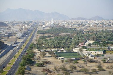 Al Suwaifa Yürüyüş Yolu 'ndaki dağdan Khor Fakkan şehri ve beyaz Al-Lo' alo 'aeyyah Camii manzarası. Khor Fakkan, Birleşik Arap Emirlikleri 'nin doğu kıyısında yer alan bir şehirdir ve Şeriat Emirliği' ne bağlı bir şehirdir.. 