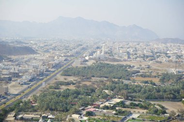 Al Suwaifa Yürüyüş Yolu 'ndaki dağdan Khor Fakkan şehri ve beyaz Al-Lo' alo 'aeyyah Camii manzarası. Khor Fakkan, Birleşik Arap Emirlikleri 'nin doğu kıyısında yer alan bir şehirdir ve Şeriat Emirliği' ne bağlı bir şehirdir.. 