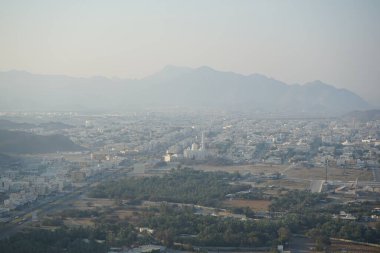 Al Suwaifa Yürüyüş Yolu 'ndaki dağdan Khor Fakkan şehri ve beyaz Al-Lo' alo 'aeyyah Camii manzarası. Khor Fakkan, Birleşik Arap Emirlikleri 'nin doğu kıyısında yer alan bir şehirdir ve Şeriat Emirliği' ne bağlı bir şehirdir.. 