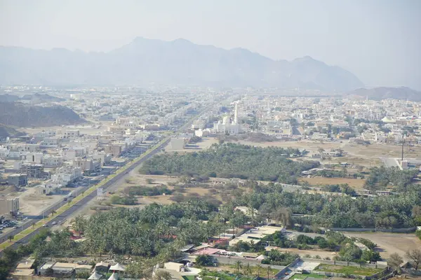 Al Suwaifa Yürüyüş Yolu 'ndaki dağdan Khor Fakkan şehri ve beyaz Al-Lo' alo 'aeyyah Camii manzarası. Khor Fakkan, Birleşik Arap Emirlikleri 'nin doğu kıyısında yer alan bir şehirdir ve Şeriat Emirliği' ne bağlı bir şehirdir.. 