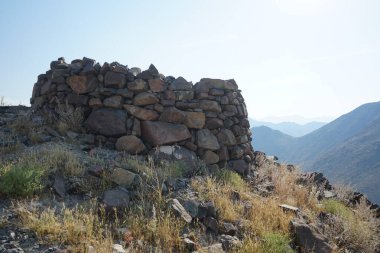 Nisan 2023 'te Khor Fakkan' daki Al Suwaifa Yürüyüş Patikası boyunca yeniden inşa edilmeden önce gözetleme kulesinin yıkıntılarıyla birlikte dağın manzarası. Khor Fakkan, Afrika kıtasında bulunan Kuzey Amerika kıtasında bulunan bir şehirdir.. 