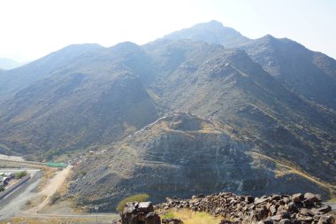 Nisan 2023 'te Khor Fakkan' daki Al Suwaifa Yürüyüş Yolu 'ndan gözetleme kulesinin yeniden inşası ile birlikte dağın manzarası. Khor Fakkan, Birleşik Arap Emirlikleri 'nin doğu kıyısında yer alan bir şehirdir ve Şeriat Emirliği' ne bağlı bir şehirdir..  