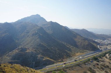 Nisan 2023 'te Khor Fakkan' daki Al Suwaifa Yürüyüş Yolu 'ndan gözetleme kulesinin yeniden inşası ile birlikte dağın manzarası. Khor Fakkan, Birleşik Arap Emirlikleri 'nin doğu kıyısında yer alan bir şehirdir ve Şeriat Emirliği' ne bağlı bir şehirdir..  