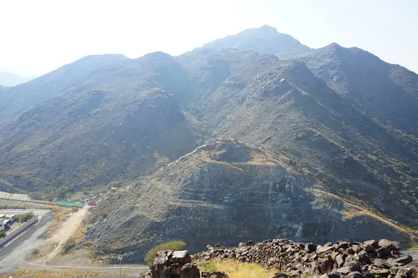 Nisan 2023 'te Khor Fakkan' daki Al Suwaifa Yürüyüş Yolu 'ndan gözetleme kulesinin yeniden inşası ile birlikte dağın manzarası. Khor Fakkan, Birleşik Arap Emirlikleri 'nin doğu kıyısında yer alan bir şehirdir ve Şeriat Emirliği' ne bağlı bir şehirdir..  