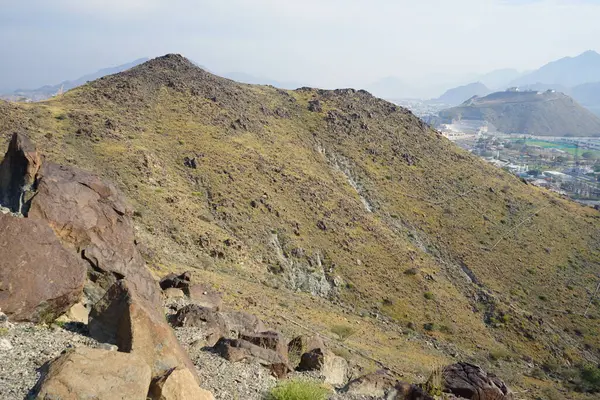 Nisan 2023 'te Khor Fakkan' daki Al Suwaifa Yürüyüş Patikası boyunca yeniden inşa edilmeden önce gözetleme kulesinin yıkıntılarıyla birlikte dağın manzarası. Khor Fakkan, Afrika kıtasında bulunan Kuzey Amerika kıtasında bulunan bir şehirdir.. 