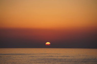 Nisan ayında Khor Fakkan sahilinden Umman Körfezi üzerinde güneşin doğuşu ve güzel doğal gökyüzü. Khor Fakkan, Afrika kıtasında bulunan Kuzey Amerika kıtasında bulunan bir şehirdir..                                