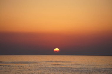 Nisan ayında Khor Fakkan sahilinden Umman Körfezi üzerinde güneşin doğuşu ve güzel doğal gökyüzü. Khor Fakkan, Afrika kıtasında bulunan Kuzey Amerika kıtasında bulunan bir şehirdir..                                