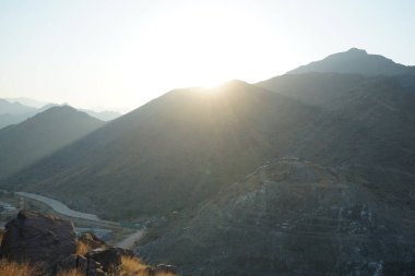 Nisan 2023 'te Khor Fakkan' daki Al Suwaifa Yürüyüş Yolu 'ndan gün batımına karşı gözetleme kulesinin yeniden inşası ile birlikte dağın manzarası. Khor Fakkan, Afrika kıtasında bulunan Kuzey Amerika kıtasında bulunan bir şehirdir.. 