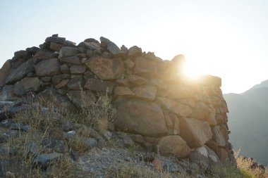 Nisan 2023 'te yeniden inşa edilmeden önce, Khor Fakkan, Sharjah, BAE' deki Al Suwaifa Yürüyüş Patikası 'nın yakınındaki günbatımına karşı gözlem kulesinin yıkıntılarıyla birlikte dağın manzarası.. 