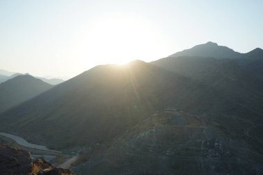 Nisan 2023 'te Khor Fakkan' daki Al Suwaifa Yürüyüş Yolu 'ndan gün batımına karşı gözetleme kulesinin yeniden inşası ile birlikte dağın manzarası. Khor Fakkan, Afrika kıtasında bulunan Kuzey Amerika kıtasında bulunan bir şehirdir.. 