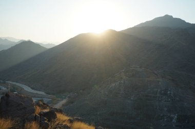 Nisan 2023 'te Khor Fakkan' daki Al Suwaifa Yürüyüş Yolu 'ndan gün batımına karşı gözetleme kulesinin yeniden inşası ile birlikte dağın manzarası. Khor Fakkan, Afrika kıtasında bulunan Kuzey Amerika kıtasında bulunan bir şehirdir.. 