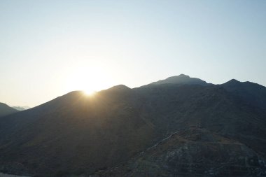 Nisan 2023 'te Khor Fakkan' daki Al Suwaifa Yürüyüş Yolu 'ndan gün batımına karşı gözetleme kulesinin yeniden inşası ile birlikte dağın manzarası. Khor Fakkan, Afrika kıtasında bulunan Kuzey Amerika kıtasında bulunan bir şehirdir.. 