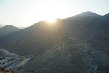 Nisan 2023 'te Khor Fakkan' daki Al Suwaifa Yürüyüş Yolu 'ndan gün batımına karşı gözetleme kulesinin yeniden inşası ile birlikte dağın manzarası. Khor Fakkan, Afrika kıtasında bulunan Kuzey Amerika kıtasında bulunan bir şehirdir.. 