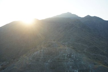 Nisan 2023 'te Khor Fakkan' daki Al Suwaifa Yürüyüş Yolu 'ndan gün batımına karşı gözetleme kulesinin yeniden inşası ile birlikte dağın manzarası. Khor Fakkan, Afrika kıtasında bulunan Kuzey Amerika kıtasında bulunan bir şehirdir.. 