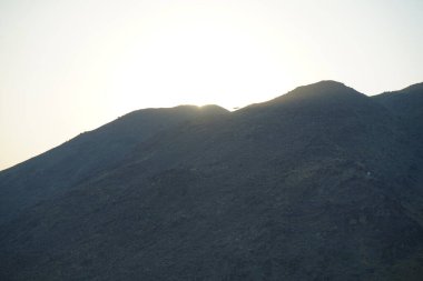 Khor Fakkan 'daki Al Suwaifa Yürüyüş Yolu' ndan Vachellia tortilis ile dağların arkasındaki günbatımı manzarası. Vachellia tortilis (