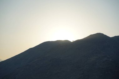 Khor Fakkan 'daki Al Suwaifa Yürüyüş Yolu' ndan Vachellia tortilis ile dağların arkasındaki günbatımı manzarası. Vachellia tortilis (
