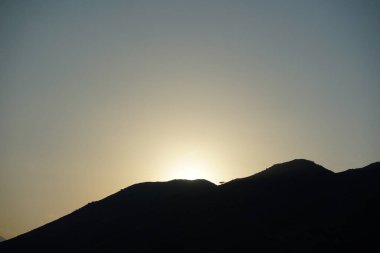 Khor Fakkan 'daki Al Suwaifa Yürüyüş Yolu' ndan Vachellia tortilis ile dağların arkasındaki günbatımı manzarası. Vachellia tortilis (