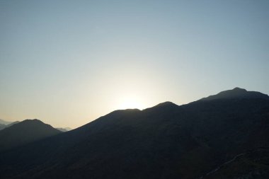 Nisan 2023 'te Khor Fakkan' daki Al Suwaifa Yürüyüş Yolu 'ndan gün batımına karşı gözetleme kulesinin yeniden inşası ile birlikte dağın manzarası. Khor Fakkan, Afrika kıtasında bulunan Kuzey Amerika kıtasında bulunan bir şehirdir.. 