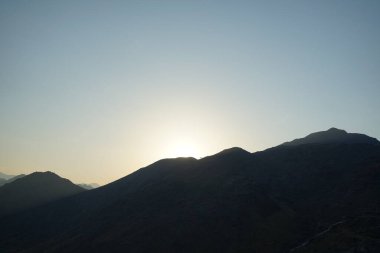 Nisan 2023 'te Khor Fakkan' daki Al Suwaifa Yürüyüş Yolu 'ndan gün batımına karşı gözetleme kulesinin yeniden inşası ile birlikte dağın manzarası. Khor Fakkan, Afrika kıtasında bulunan Kuzey Amerika kıtasında bulunan bir şehirdir.. 