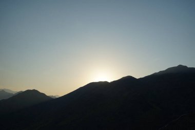 Khor Fakkan 'daki Al Suwaifa Yürüyüş Yolu' ndan Vachellia tortilis ile dağların arkasındaki günbatımı manzarası. Vachellia tortilis (