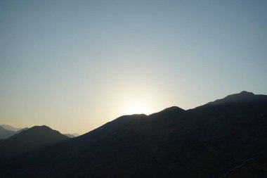 Khor Fakkan 'daki Al Suwaifa Yürüyüş Yolu' ndan Vachellia tortilis ile dağların arkasındaki günbatımı manzarası. Vachellia tortilis (