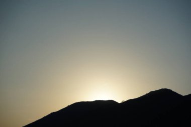 Khor Fakkan 'daki Al Suwaifa Yürüyüş Yolu' ndan Vachellia tortilis ile dağların arkasındaki günbatımı manzarası. Vachellia tortilis (