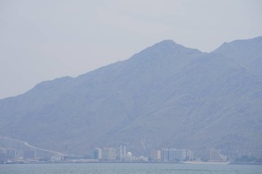 Nisan ayında Umman Körfezi manzarası ve Khor Fakkan kenti kıyıları. Khor Fakkan, Birleşik Arap Emirlikleri 'nin doğu kıyısında, Şeriat Emirliği' ne bağlı bir şehirdir..  