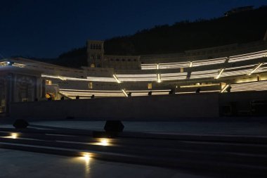 Nisan ayında akşam aydınlatmalı Khor Fakkan Amfitiyatrosu manzarası. Khor Fakkan Amfitiyatrosu, Khor Fakkan 'da yer alan bir açık hava tiyatrosudur. Rughaylat Yolu, Al Mudeife 1 