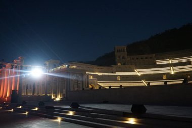 Nisan ayında akşam aydınlatmalı Khor Fakkan Amfitiyatrosu manzarası. Khor Fakkan Amfitiyatrosu, Khor Fakkan 'da yer alan bir açık hava tiyatrosudur. Rughaylat Yolu, Al Mudeife 1 