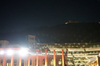 Nisan ayında akşam aydınlatmalı Khor Fakkan Amfitiyatrosu manzarası. Khor Fakkan Amfitiyatrosu, Khor Fakkan 'da yer alan bir açık hava tiyatrosudur. Rughaylat Yolu, Al Mudeife 1 