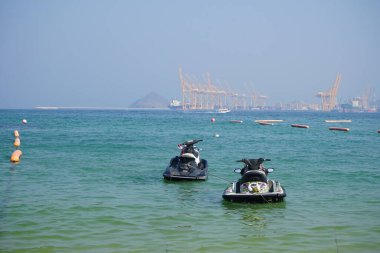 Khor Fakkan, Sharjah, BAE - 21 Nisan 2023: PWC ve diğer yüzey taşıma gemileri Khor Fakkan Sahili 'nde Umman Körfezi' nin sularındalar. Kişisel su aracı, PWC, su motosikleti, bir su gemisidir.. 
