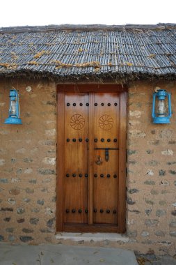 Gazyağı lambası biçiminde fenerler, Khor Fakkan 'ın Tarihi Köyü' ndeki eski binanın kapısının yanındaki duvara asılır..  