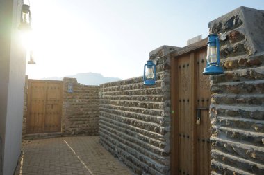 Gazyağı lambası biçiminde fenerler, Khor Fakkan 'ın Tarihi Köyü' ndeki eski binanın kapısının yanındaki duvara asılır..  